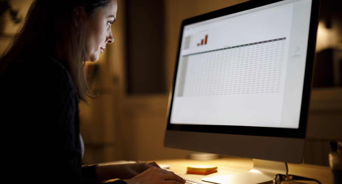 Serious woman working late at home on laptop