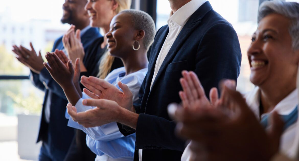 Diverse businesspeople smiling and clapping after a presentation in a boardroom