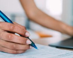 Woman on laptop and writing an application for a teaching job