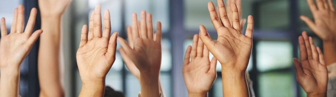 Hands raised in question to promote learning