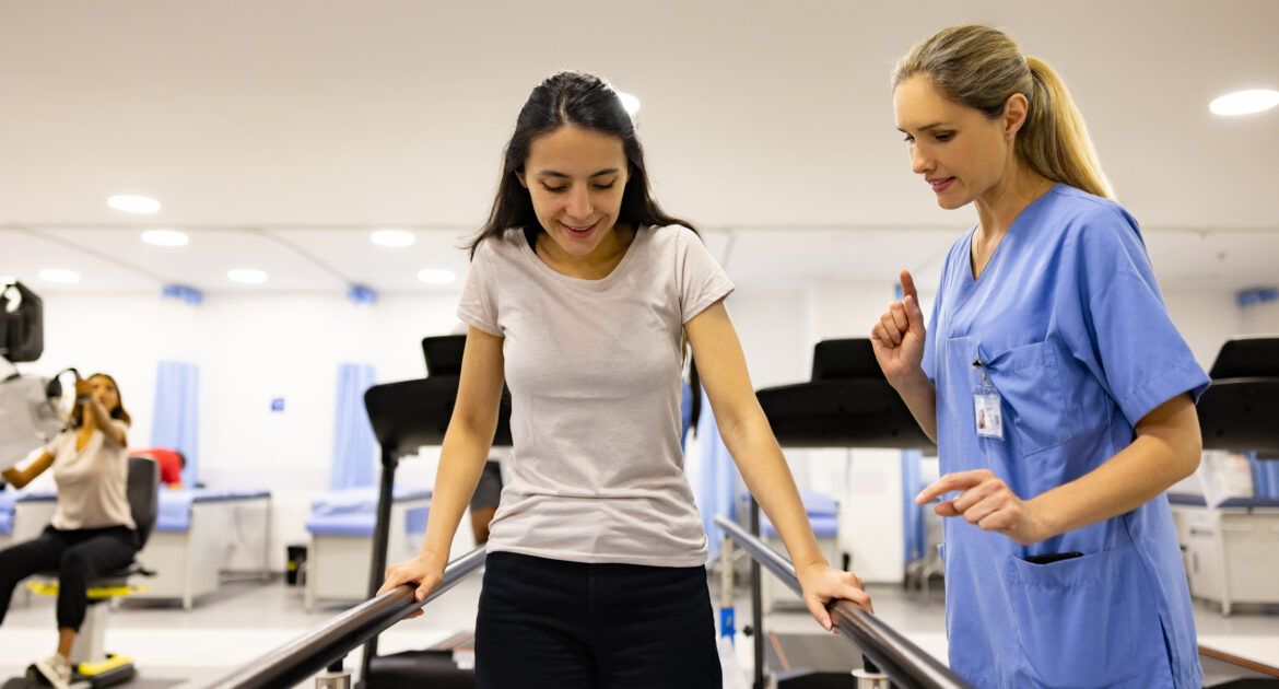 Patient in physical therapy walking on the parallel bars