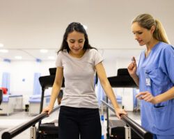 Patient in physical therapy walking on the parallel bars