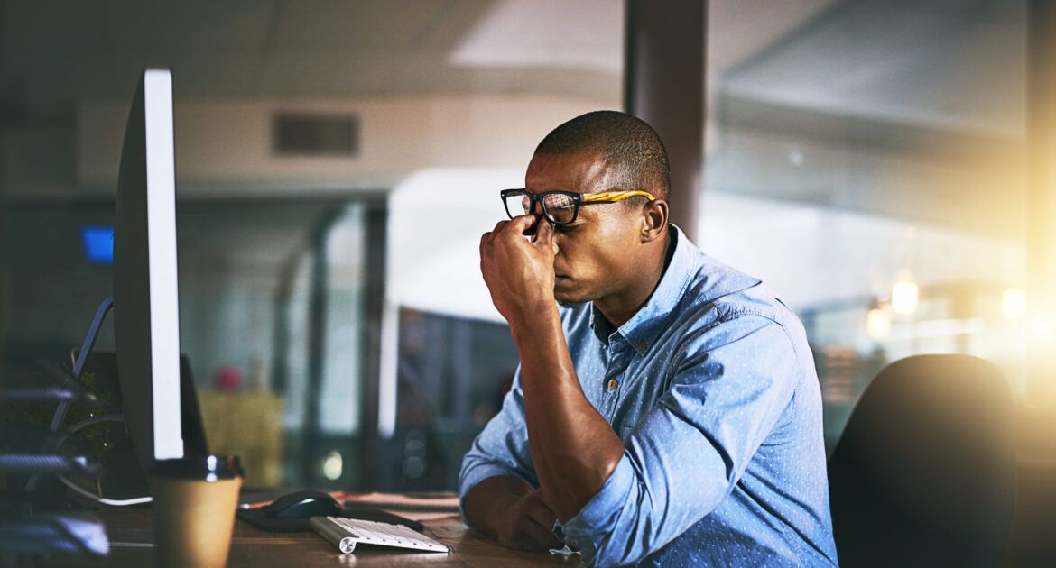 young man looking stressed at a desk