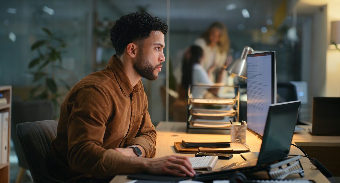 Office, night and businessman with computer for research, online information and solution for startup. Screen, male employee or digital marketing specialist with laptop for seo, keywords or web tools