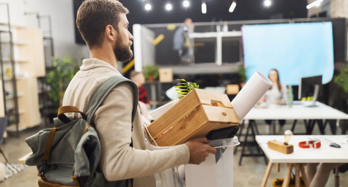 young man leaving office after being made redundant