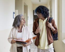 University tutor and student walking down university corridor